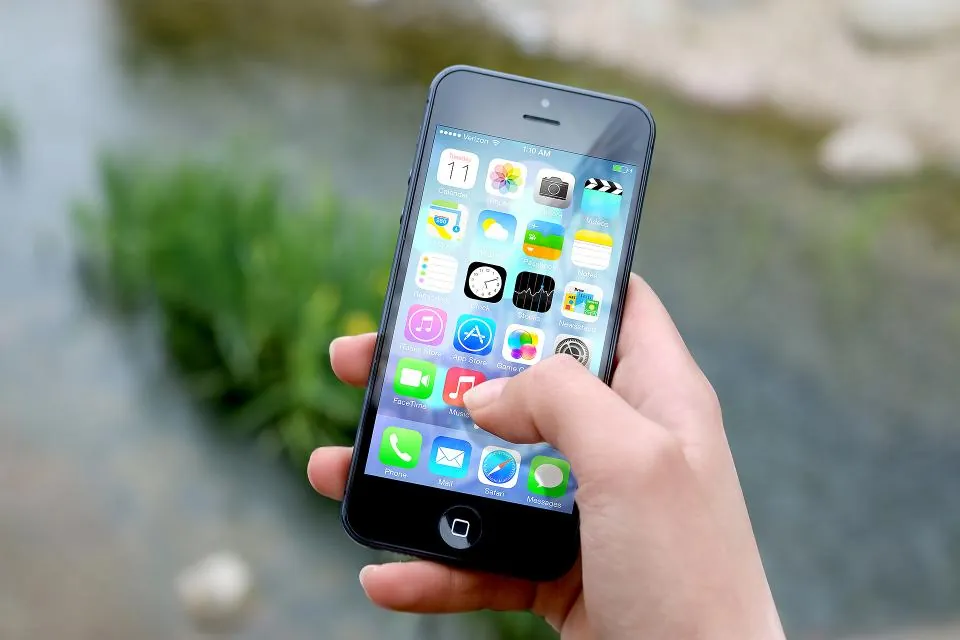 Elde tutulan iPhone ana ekranında uygulama simgeleri, App Store reklamlarının hedef kitlesi