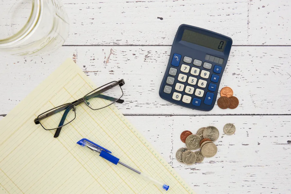 Hesap makinesi, bozuk paralar ve not kâğıdıyla e-ticaret sitesi kurulum bütçesi planlama masası