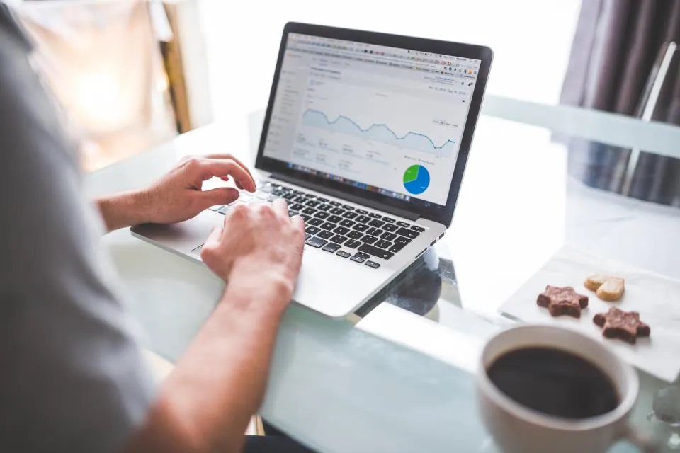 Dizüstü bilgisayarda Google Ads ve Meta Ads reklam performans grafiklerini inceleyen kişi