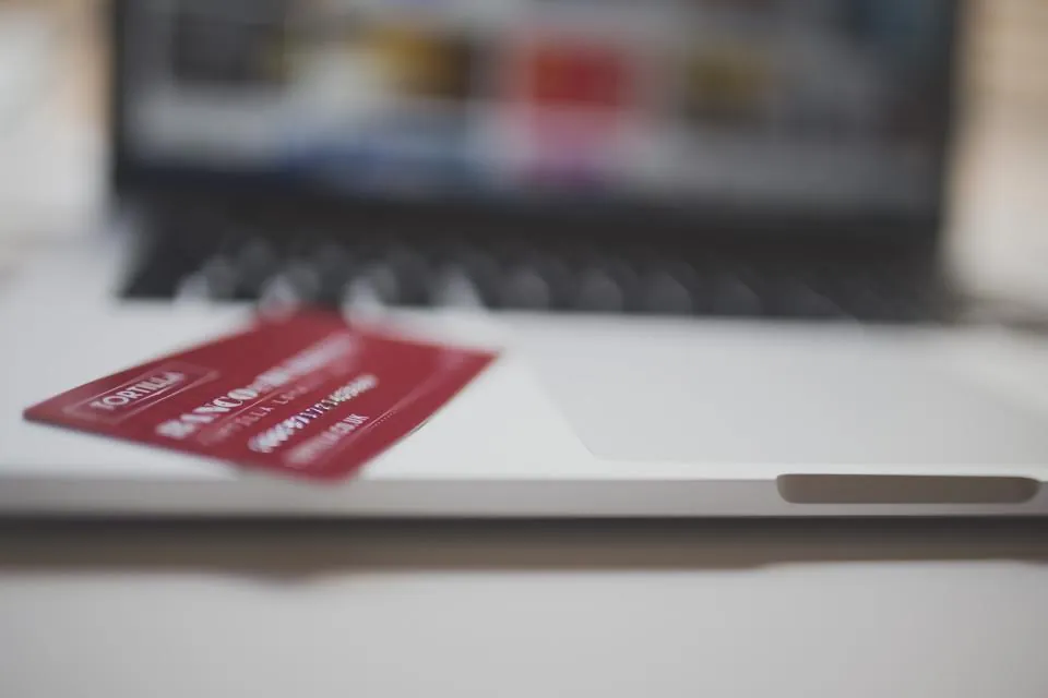Dizüstü bilgisayarın önünde kredi kartı, e-ticaret sitesinde sanal POS ile ödeme