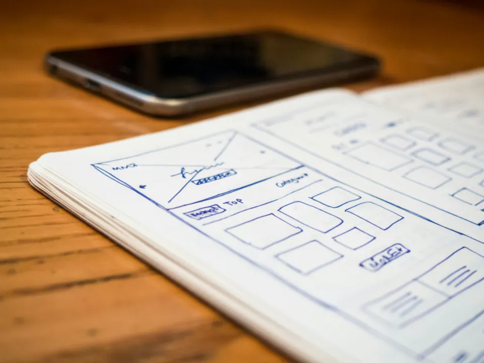 Kâğıda çizilmiş web sitesi wireframe taslakları, proje kapsamının fiyatı nasıl belirlediğini gösteriyor