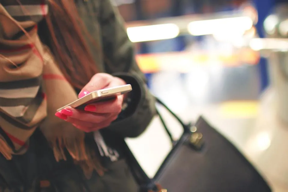 Şehirde akıllı telefonunda uygulama kullanan kadın, mobil uygulama reklamlarının ulaştığı kullanıcı