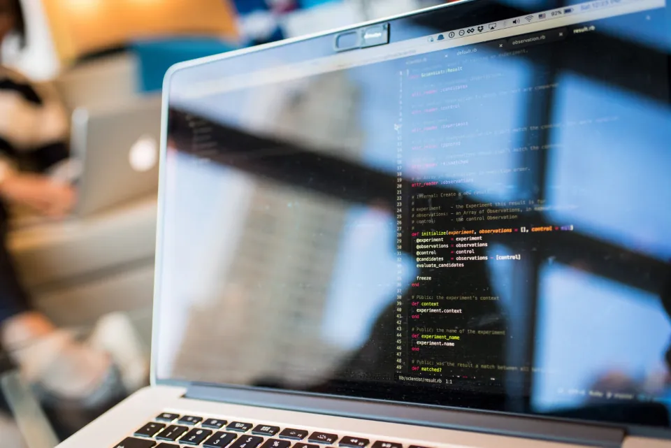 Dizüstü bilgisayar ekranında kod editörü, WordPress ile özel yazılım arasında karar anı